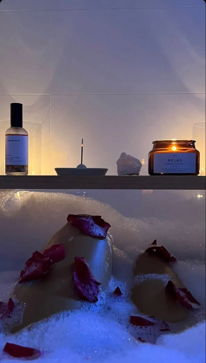 Blue lit bath scattered with petals