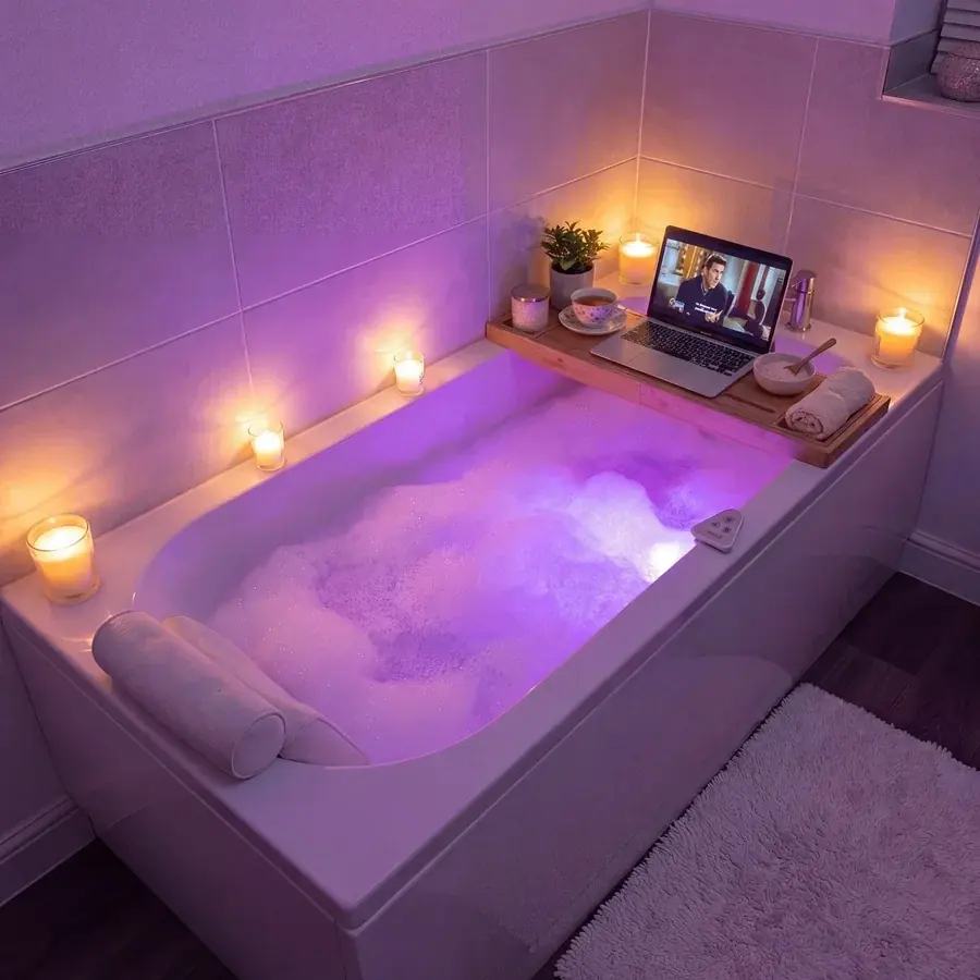A violet lit bath with candles and the door closed