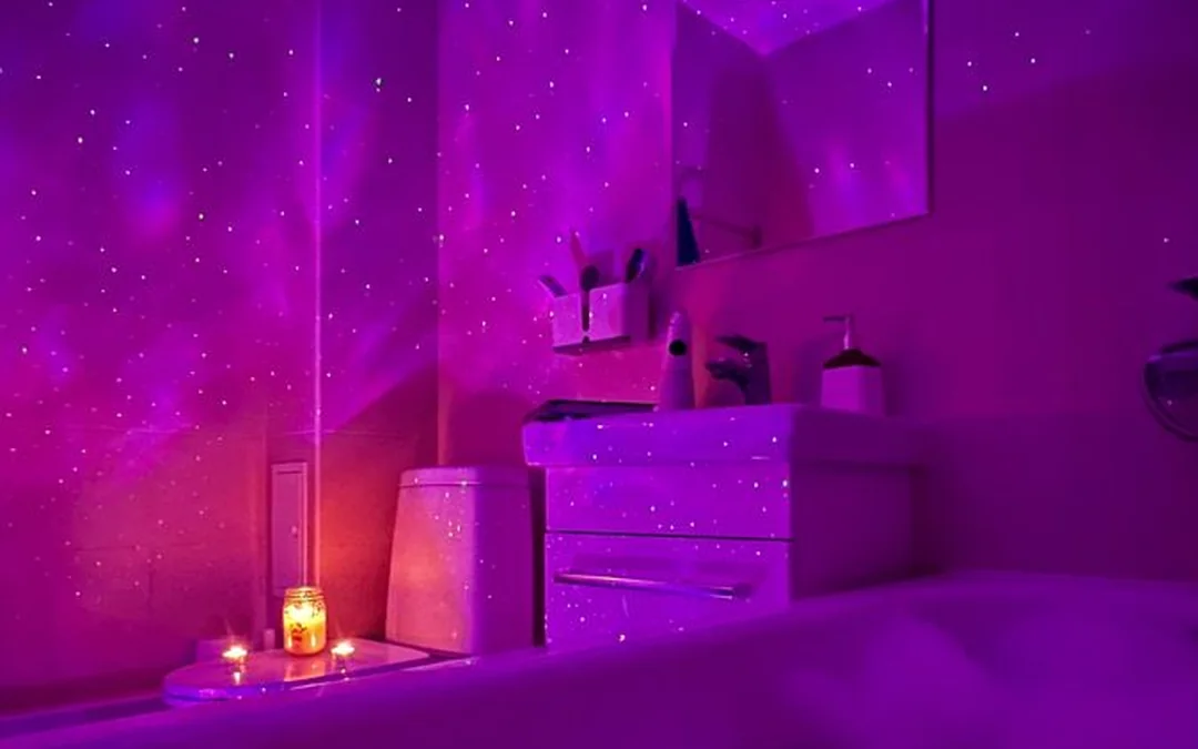 A whole bathroom lit purple, the jetted bath glowing and churning