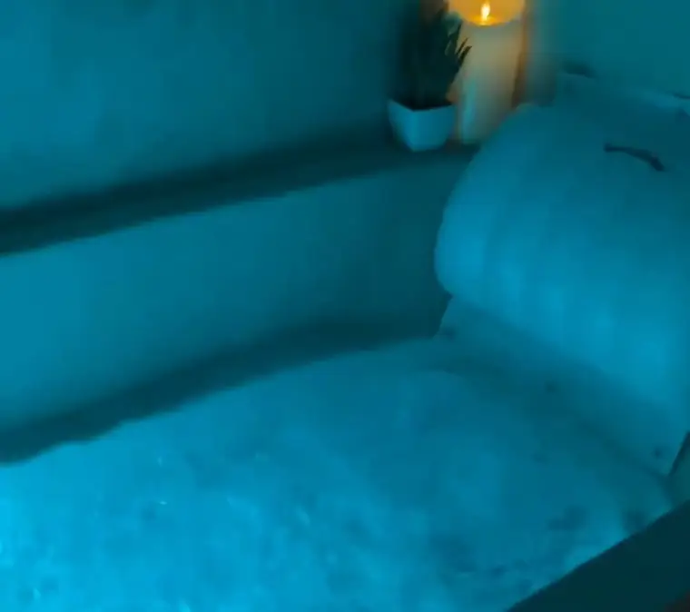 Turquoise light glowing through a full bath