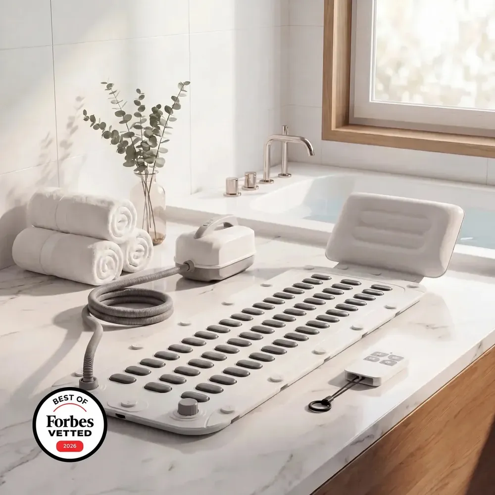 The DeepSoak Pro mat laid out beside a bath